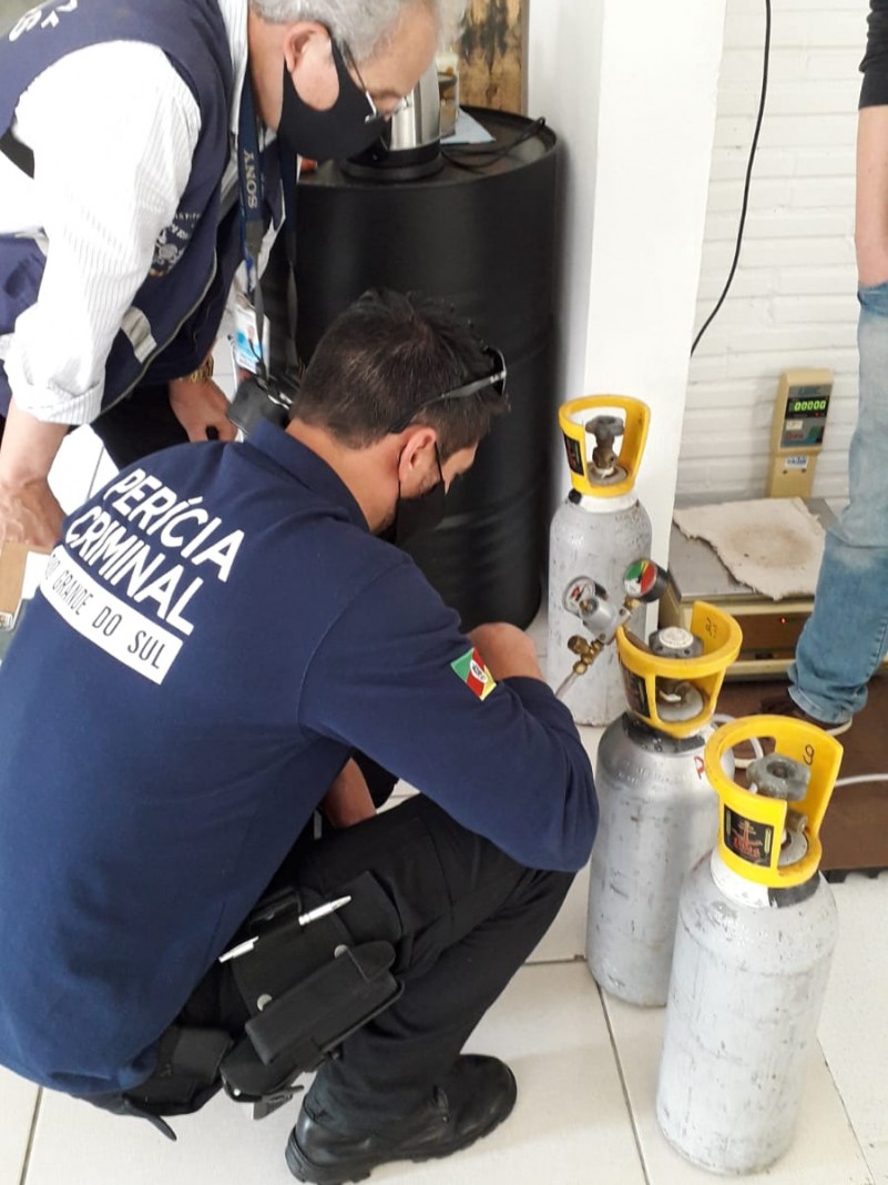Dois peritos observam cilindros em empresa fornecedora
