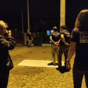 Fotografo de costas, mulher de costas e dois policiais civis de costas, simulando um caso. 