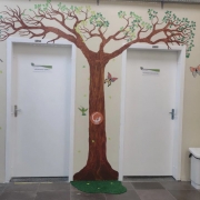 Duas portas brancas com árvore pintada na parede