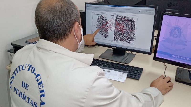 Imagem de um papiloscopista trabalhando na identificação de digitais.