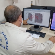 Imagem de um papiloscopista trabalhando na identificação de digitais.