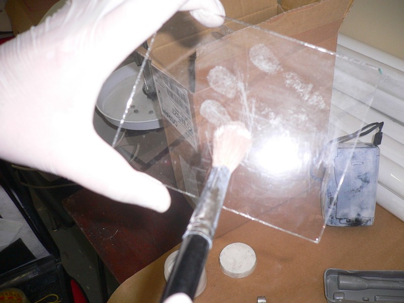 Imagem de um papiloscopista analisando vestígios de digitais.