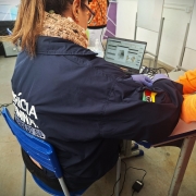 Fotografia de agente do Instituto-Geral de Perícias coletando impressões digitais durante o mutirão, para encaminhamento da Carteira de Identidade.