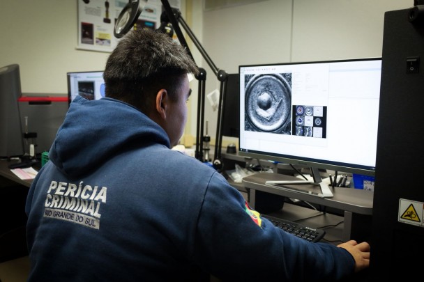 Fotografia mostra servidor usando computador no laboratório de balística