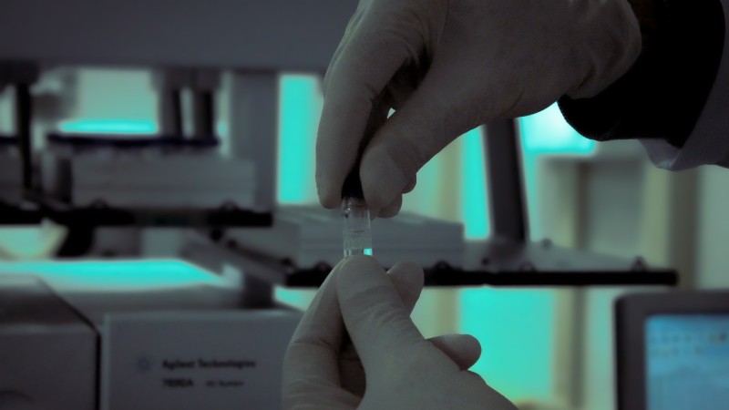 Imagem que mostra, em zoom, profissional da Divisão de Química Forense do IGP trabalhando em uma amostra.