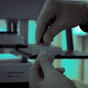 Imagem que mostra, em zoom, profissional da Divisão de Química Forense do IGP trabalhando em uma amostra.