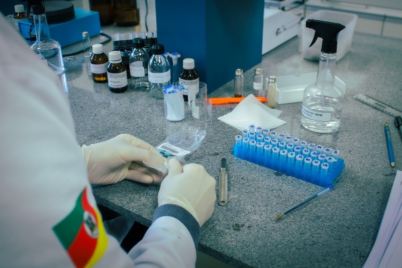 Imagem mostra profissional da Divisão de Química Forense trabalhando em uma amostra.